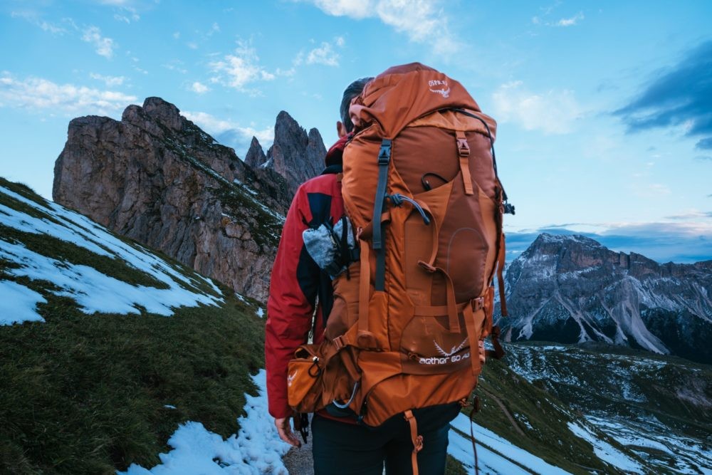 chico de espaldas con mochila en paisaje natural